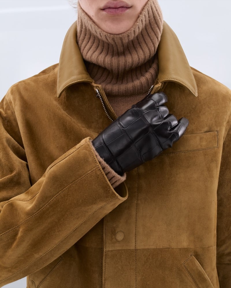 Dario Tonin wears a tan suede shirt jacket with leather collar over a camel ribbed turtleneck with black croc-embossed leather gloves