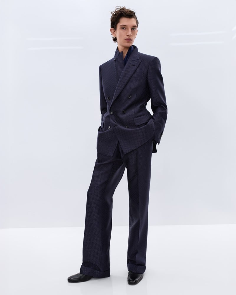 Cirillo wears a navy textured double-breasted suit over a navy silk shirt with black leather Chelsea boots