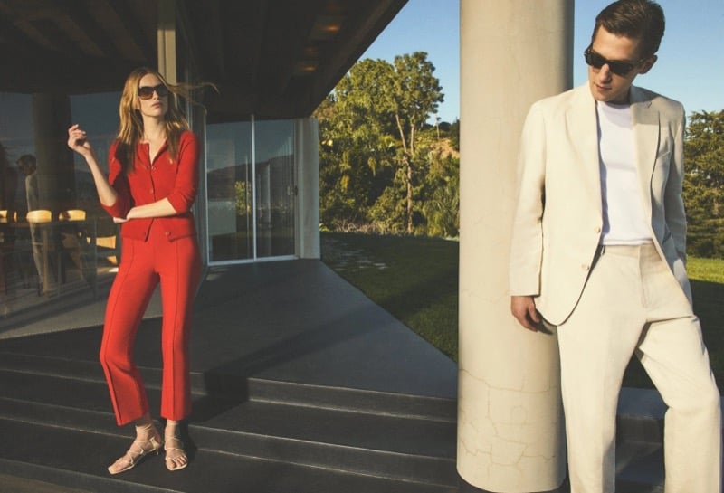 Liz Kennedy in a red knit cardigan suit and Anatol Modzelewski in an ivory linen-cotton suit with a white T-shirt photographed at a modernist Los Angeles home for Vince spring 2026