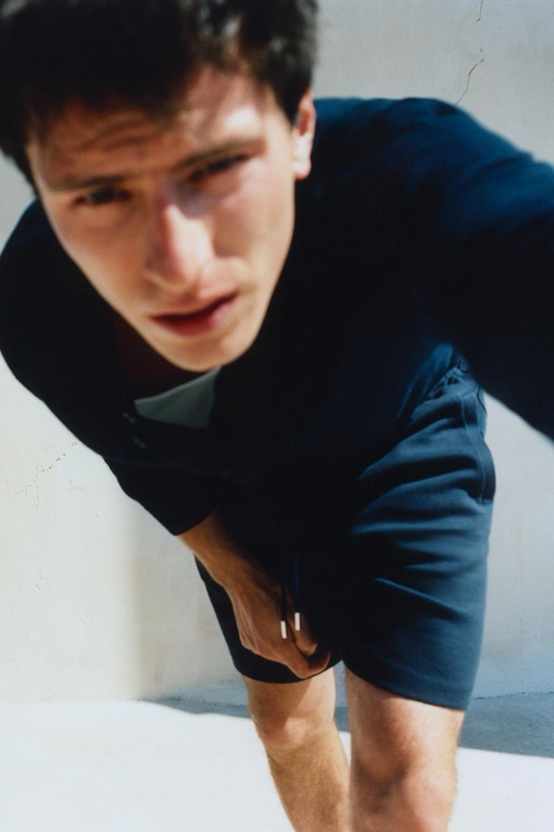Close-up of Clément Laguardia leaning toward the camera in a navy button-up shirt with the top buttons undone
