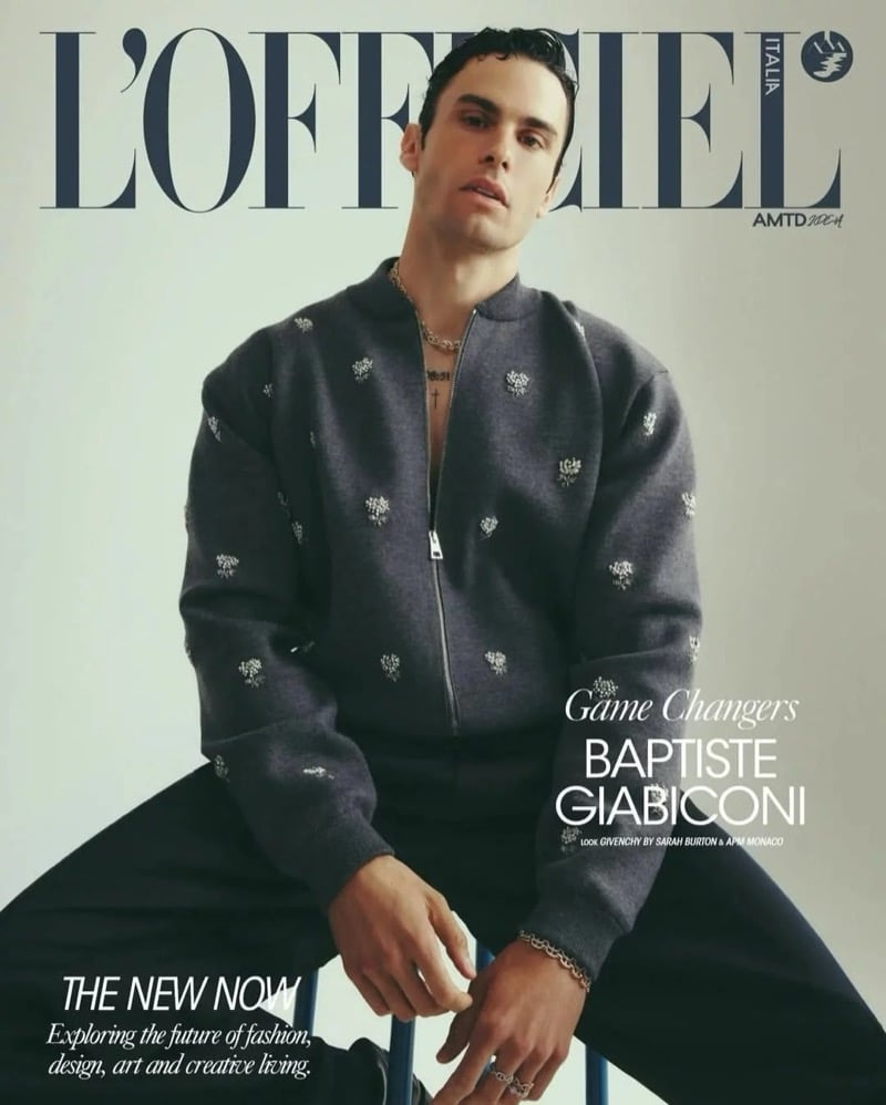 Baptiste Giabiconi sits for the cover of L'Officiel Hommes Italia in a gray floral-embroidered Givenchy bomber jacket and layered chain necklaces
