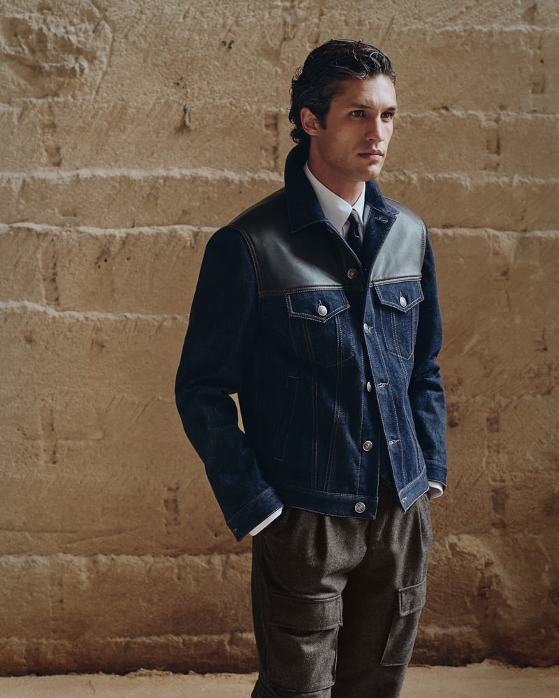 Francisco Henriques wears a leather-yoke denim trucker jacket with a white shirt and tie over cargo trousers for Brunello Cucinelli's fall 2026 edit