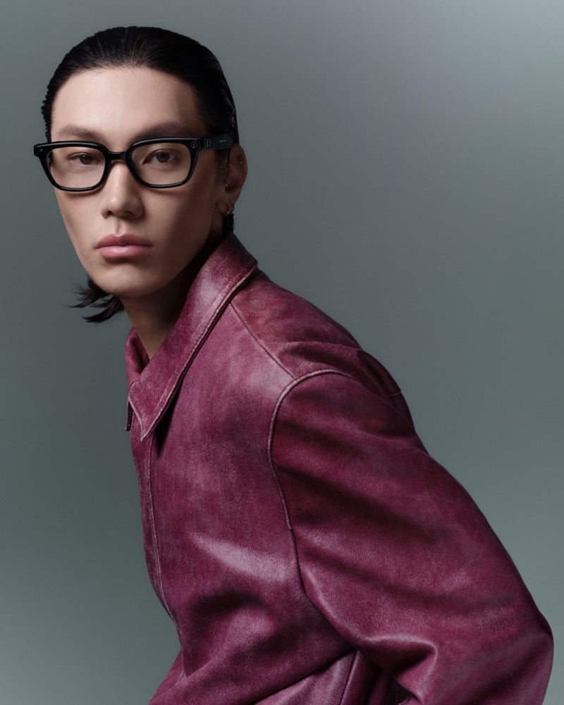 Hing wears black square-frame intelligent eyewear glasses with slicked-back hair and a weathered burgundy leather jacket, for Gentle Monster's intelligent eyewear collection