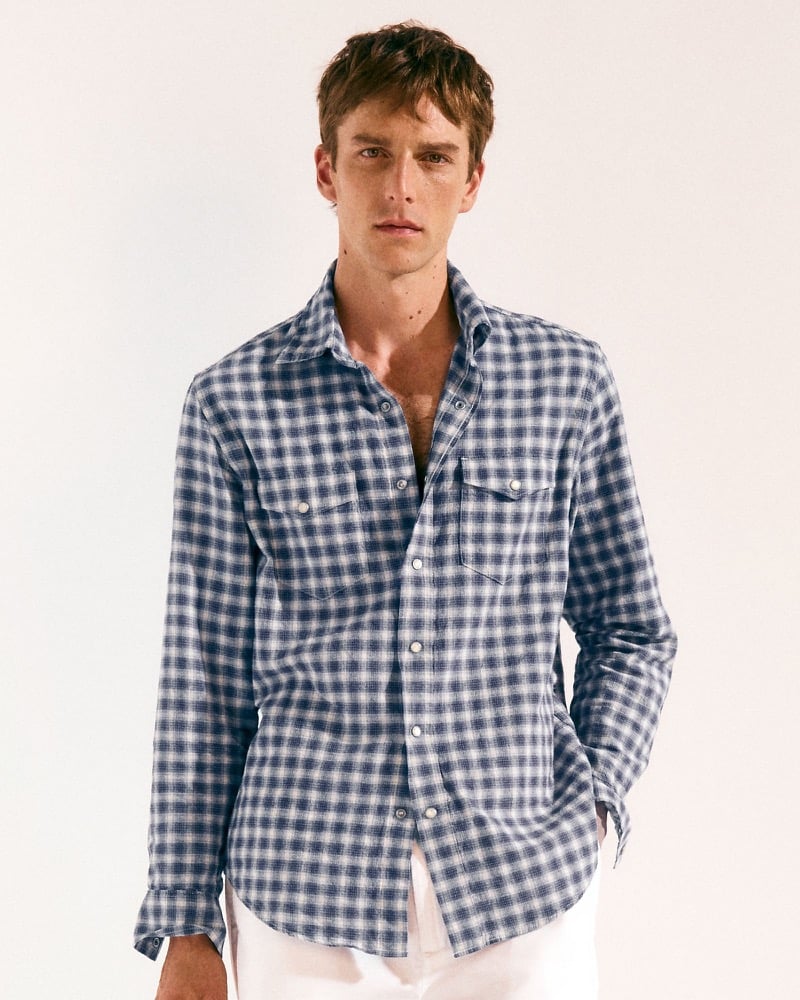Quentin Demeester in a blue and white check western shirt with white trousers