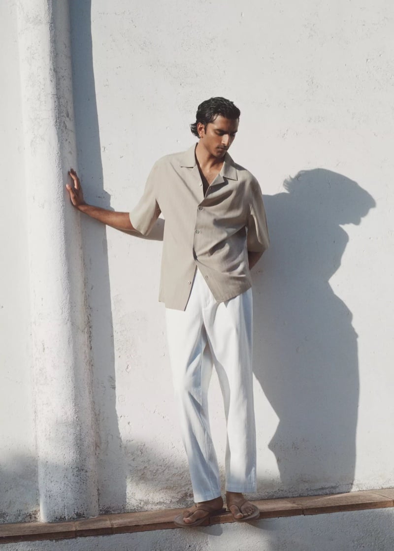 Jeenu Mahadevan in a beige camp-collar shirt leaning against a wall