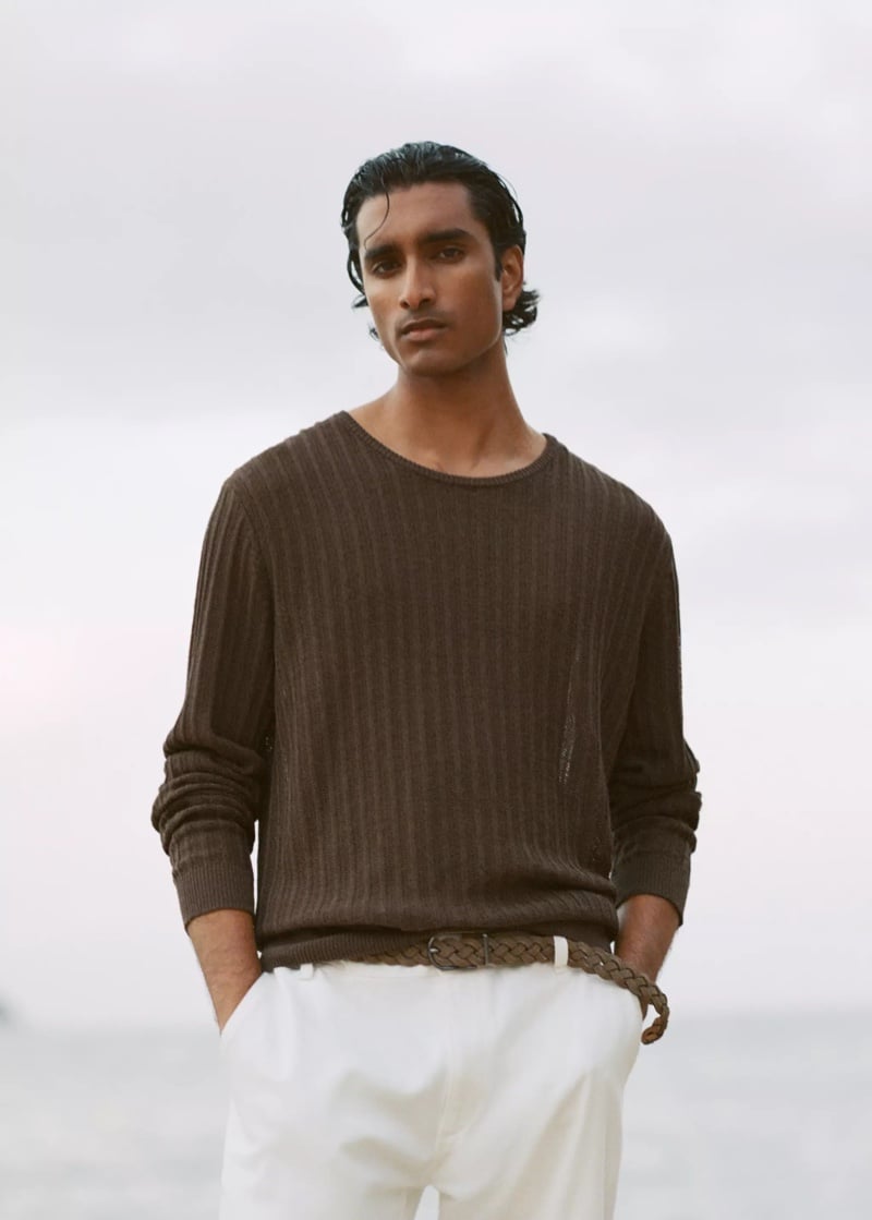 Jeenu Mahadevan in a brown ribbed sweater with a braided belt at the beach