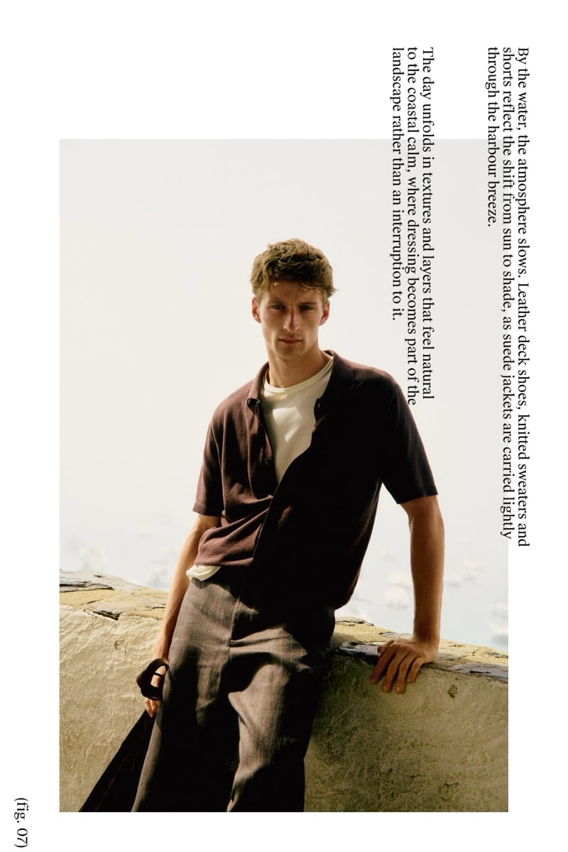 Graphic page of Vasko Luyckx in a maroon shirt half-tucked over a white tee and gray-brown trousers, holding a sandal while leaning on a stone ledge above the harbor