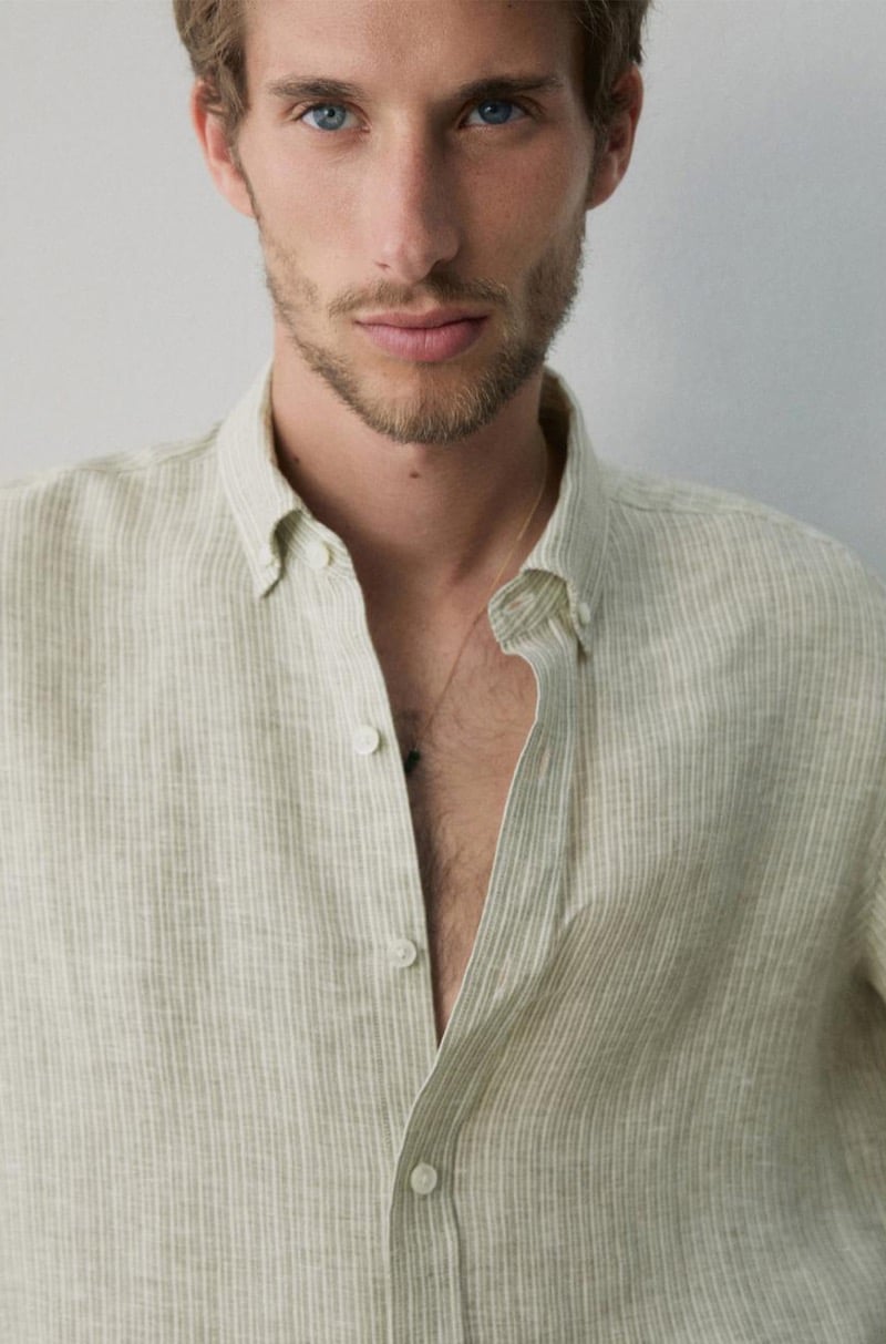 Close-up portrait of Aristide Deslandes in a pale striped linen shirt open at the collar