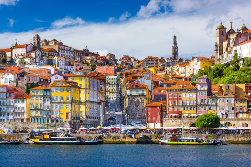 Colorful riverside buildings and traditional boats along the Douro River in Porto's Ribeira district