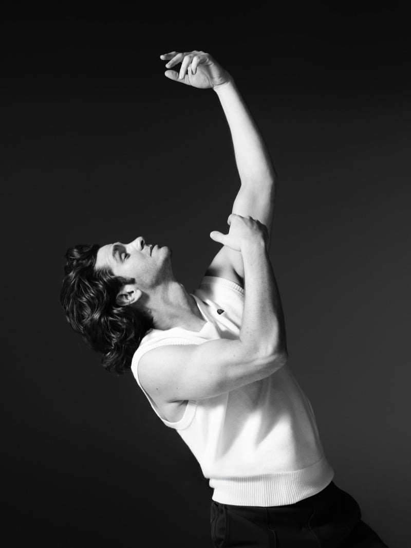 Andrew Garfield wears a white knit vest with his arm raised in a black-and-white image for ellesse's 2026 campaign