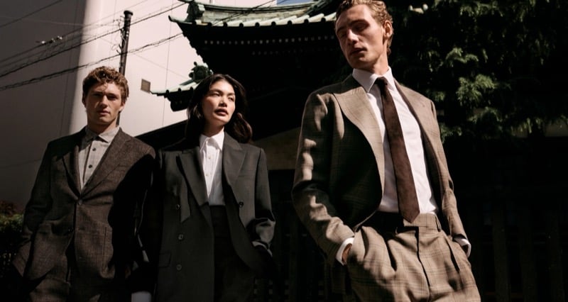 Valentin Humbroich in brown tweed tailoring, Rina Fukushi in an oversized gray suit, and Aubrey O'Mahony in a tan glen-check suit with a brown tie outside a Tokyo temple for Banana Republic's September 2026 edit