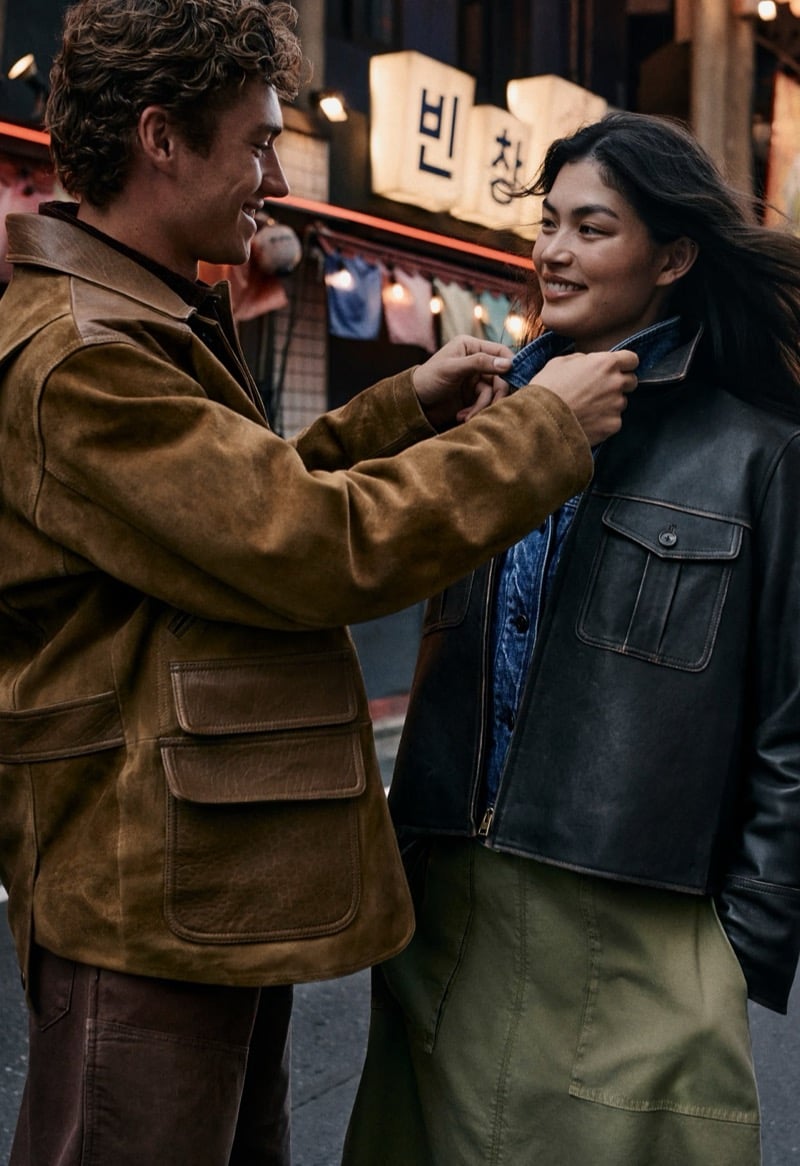 Valentin Humbroich in a suede trucker jacket adjusts the collar of Rina Fukushi's leather jacket on a lantern-lit Tokyo street for Banana Republic's September 2026 edit