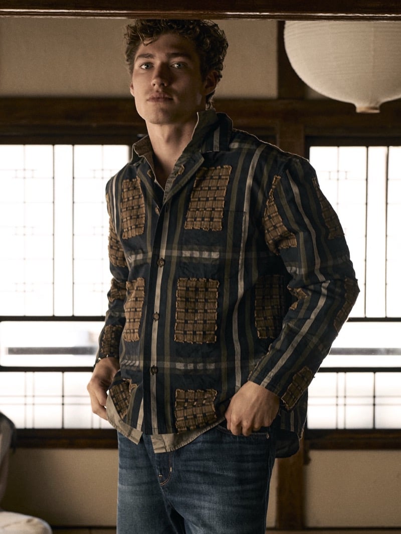 Valentin Humbroich in a dark patchwork-plaid shirt jacket over a light shirt and jeans in a traditional Japanese interior for Banana Republic's September 2026 edit