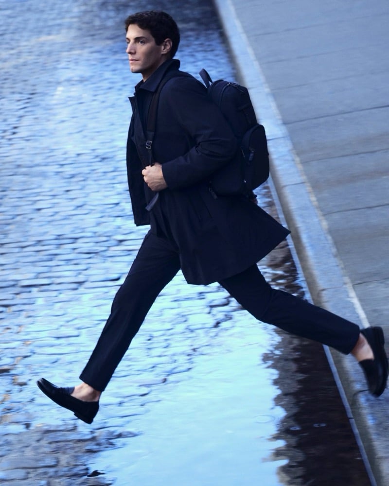 Marcos Fecchino leaps across a wet New York street in a navy suit and BOSS backpack for the BOSS Performance edit.