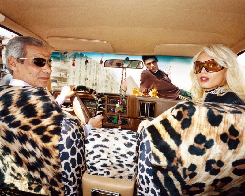 A local taxi driver and Lulu Wood ride in a car upholstered in leopard print along a Cairo street
