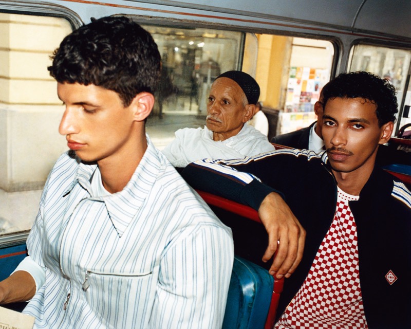 Youssef Rocha and Mohamed Hassan seated on a public bus in Cairo, with an older local passenger behind them