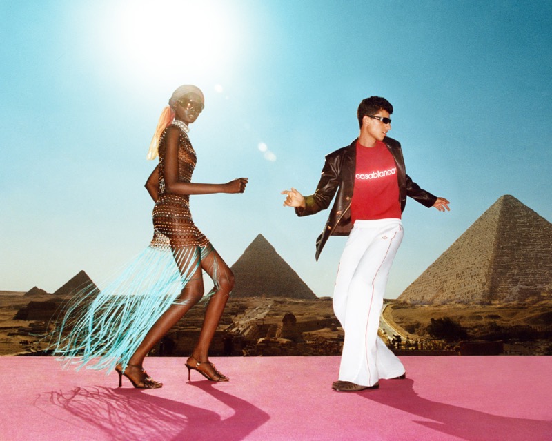 Adhar Abiem in a fringed beaded dress and Youssef Rocha in a red Casablanca T-shirt and leather jacket, dancing in front of the Pyramids of Giza
