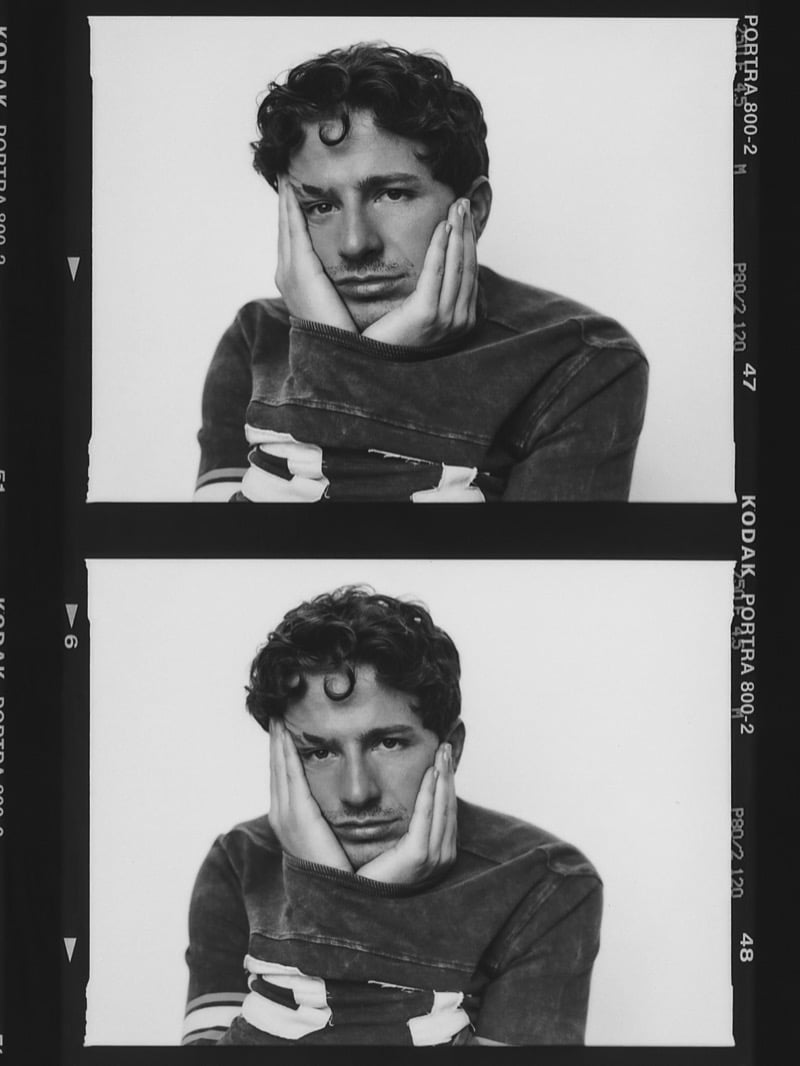 Black-and-white contact sheet of Charlie Puth resting his face in his hands in a striped sweater, two nearly identical frames