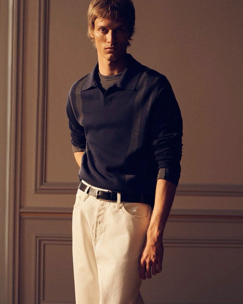 Yeray Allgayer wears a dark two-tone knit polo with pale wide-leg jeans and a black belt