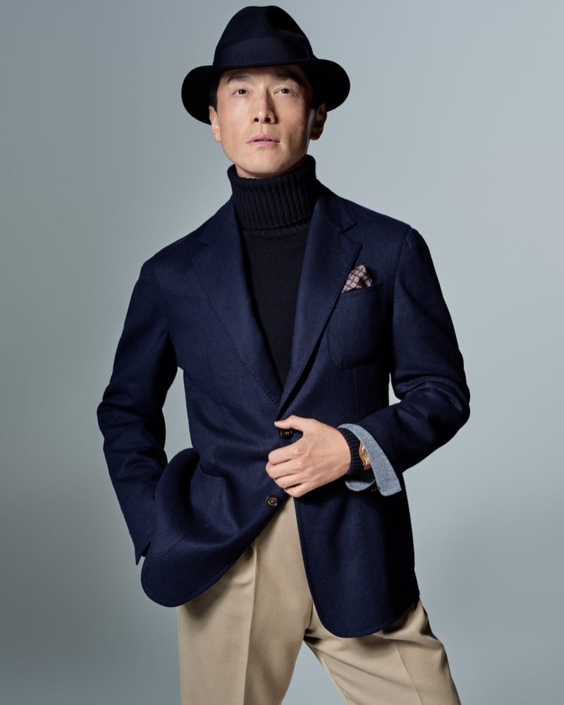 Daisuke Ueda wears a navy fedora hat with a navy blazer, black turtleneck and tan trousers for Dunhill's fall-winter 2026 campaign