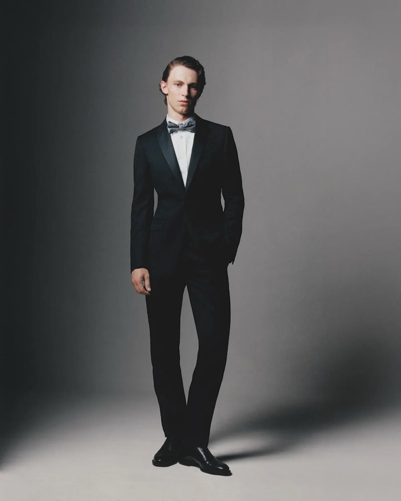 A model in a tuxedo with a patterned bow tie