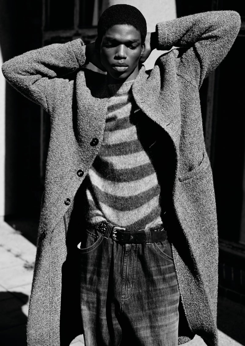 Alexander Kosi in a boucle overcoat over a striped sweater and jeans, photographed in black and white for Emporio Armani's fall-winter 2026 campaign