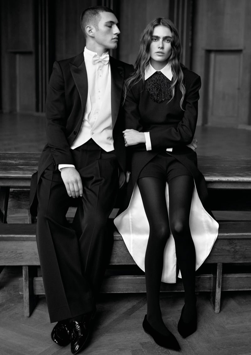 Cameron Phillimore in evening tails and a bow tie beside Mia Armstrong in a dark dress with an oversized pointed collar and beaded bib, in a black-and-white frame for Emporio Armani's fall-winter 2026 campaign