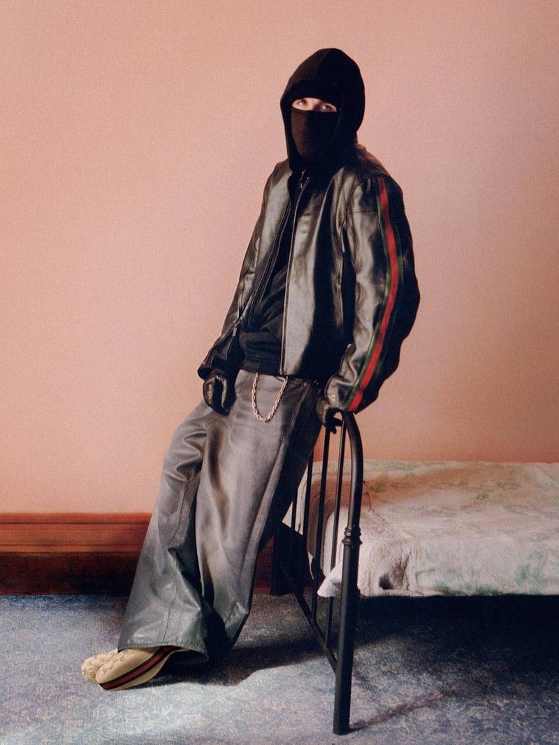 EsDeeKid wears a balaclava and a leather jacket striped in Gucci's green-and-red Web, with wide silver-toned leather trousers and a GG monogram sneaker