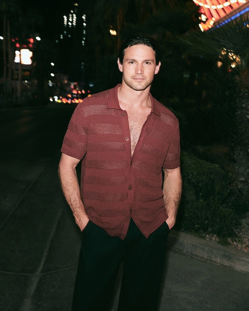 Giacomo Cavalli in an open-knit striped sweater polo at night