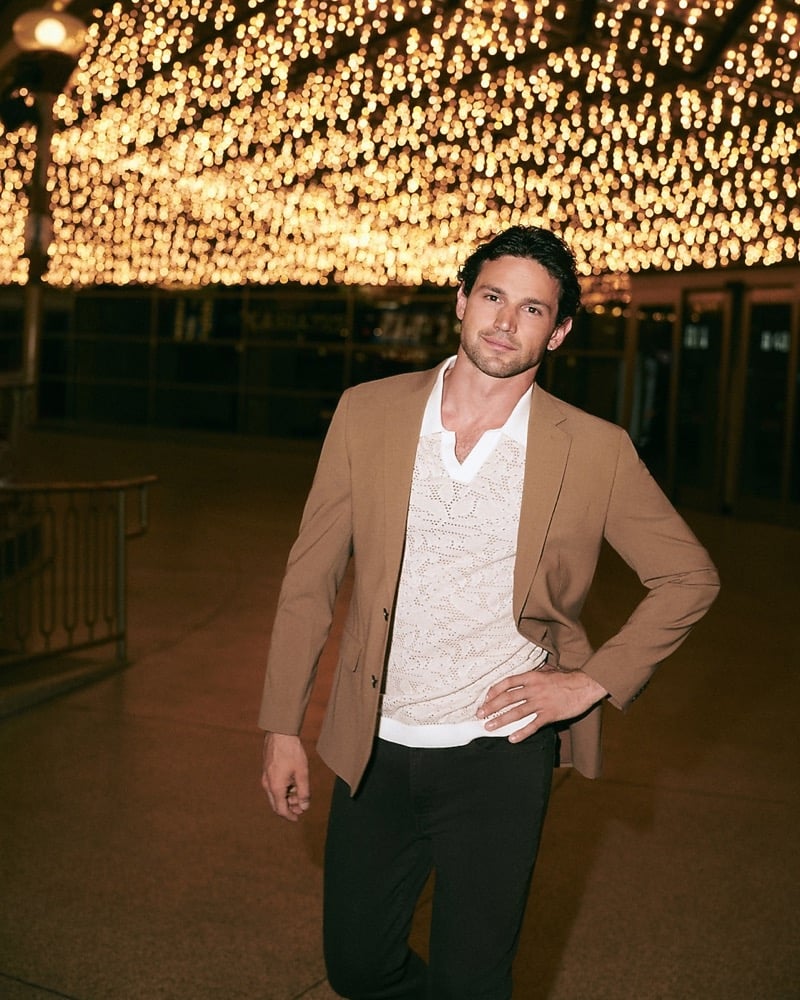 Giacomo Cavalli in a light brown tech suit jacket over an openwork knit polo