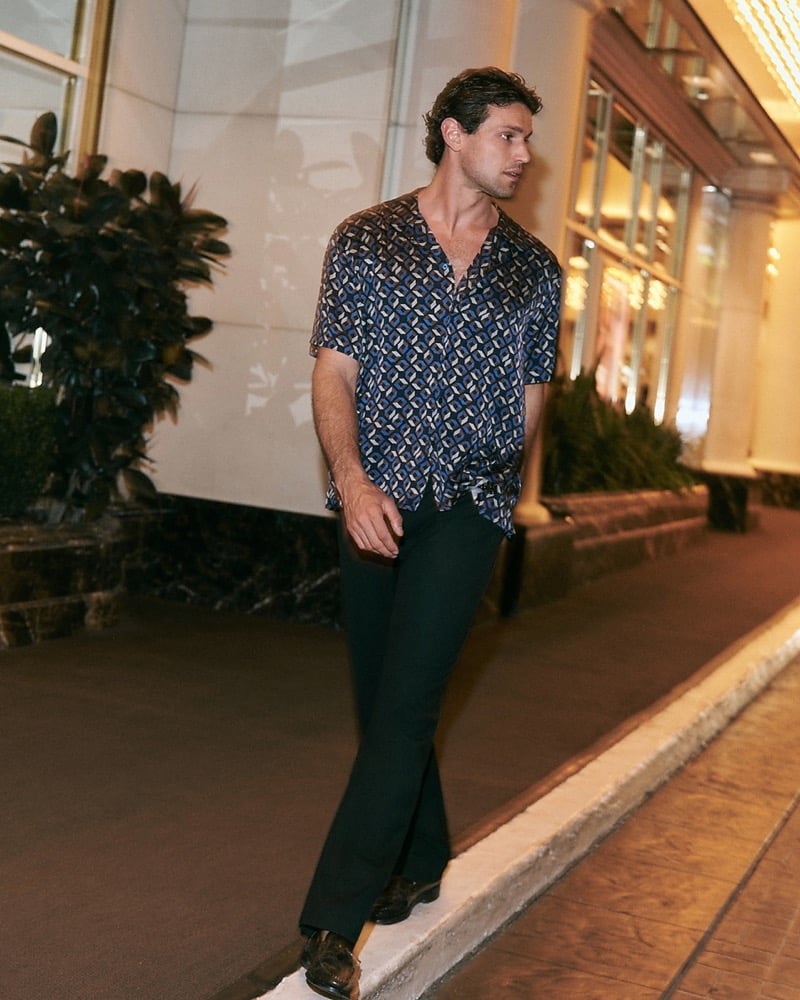 Giacomo Cavalli in a geo cube print resort shirt walking at night