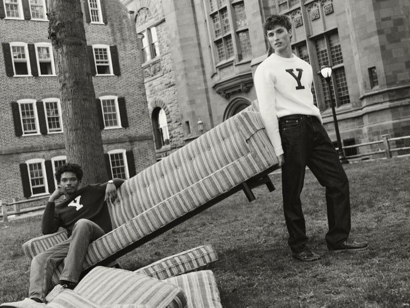 Black and white image of Nile Winchester and Jack Lumsden with a couch and mattress on the lawn, both in Yale letter sweaters