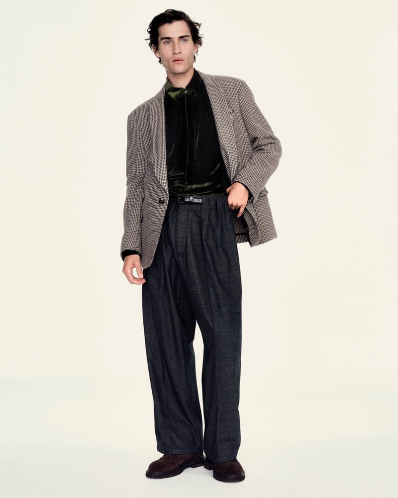 Liam Kelly wears a houndstooth blazer over a dark green velvet shirt with pleated trousers and suede boots for Giorgio Armani's fall-winter 2026 campaign