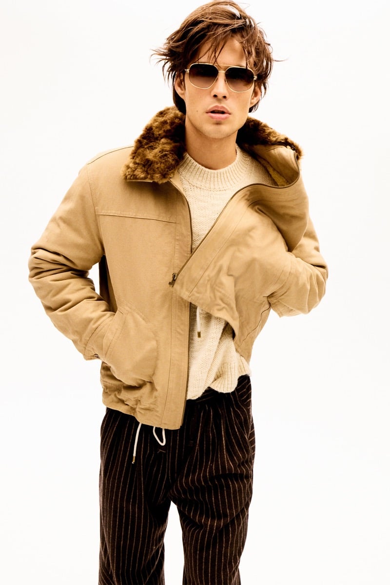 Louis Baines in a tan jacket with a faux fur collar and sunglasses, wearing pinstripe trousers, for Isabel Marant Fall 2026