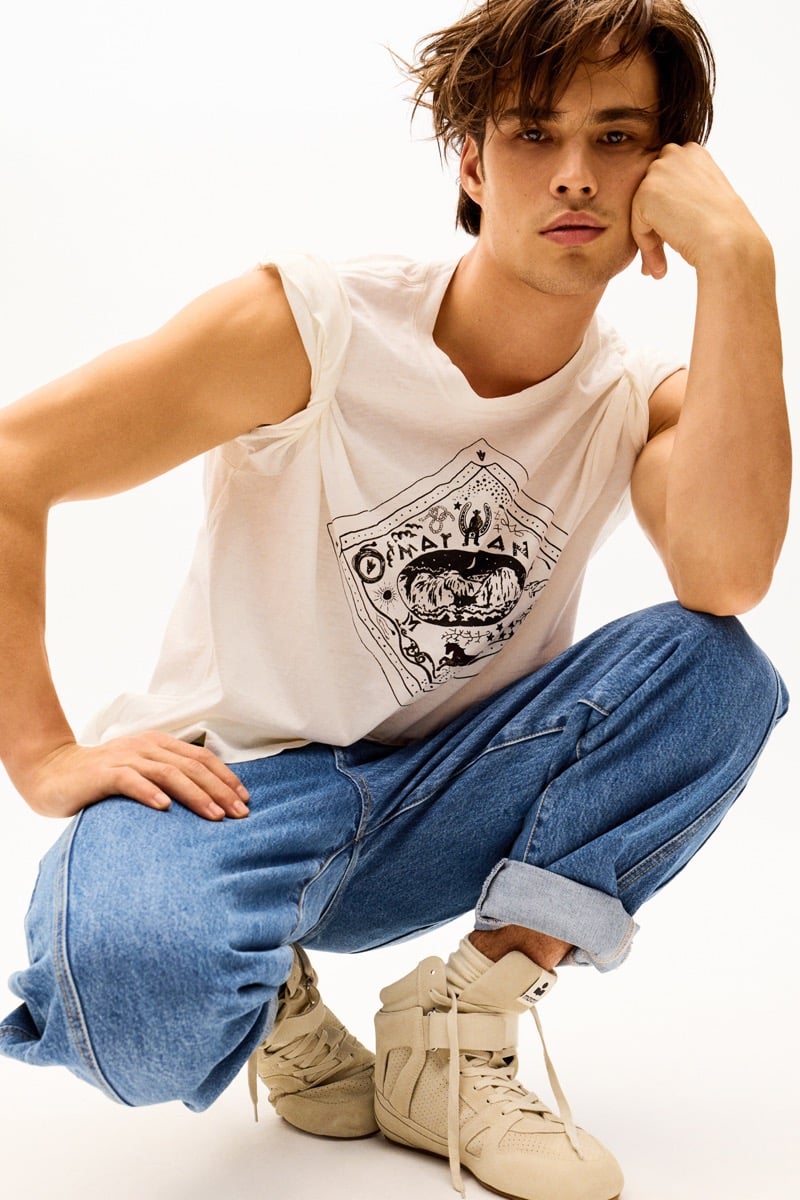 Louis Baines in a graphic tank top and wide-leg jeans, wearing high-top sneakers, for Isabel Marant Fall 2026