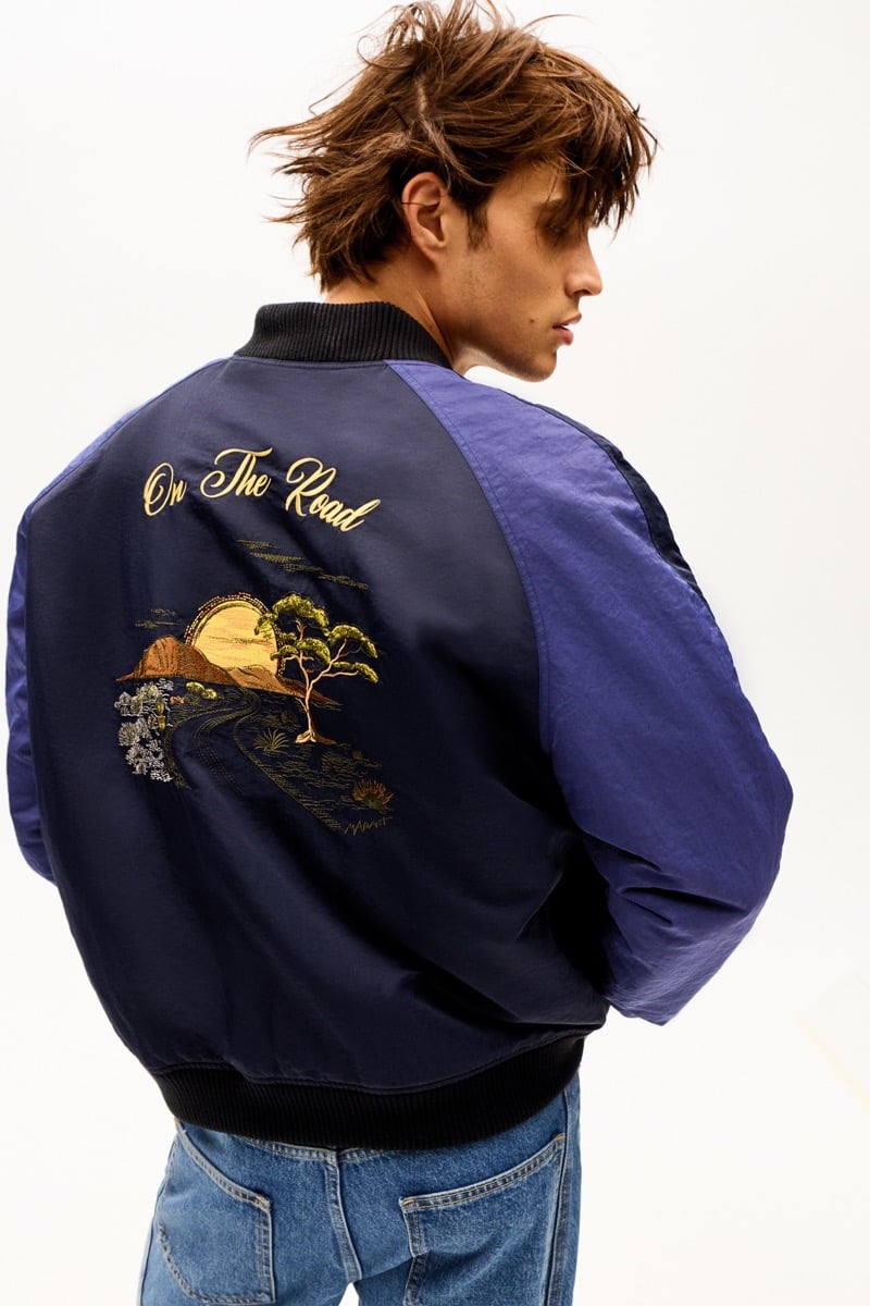 Louis Baines in an embroidered souvenir bomber jacket reading 'On The Road,' seen from the back, for Isabel Marant Fall 2026