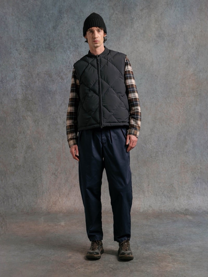 Man in a black quilted vest over a plaid shirt, wearing a beanie, for Kestin Fall 2026