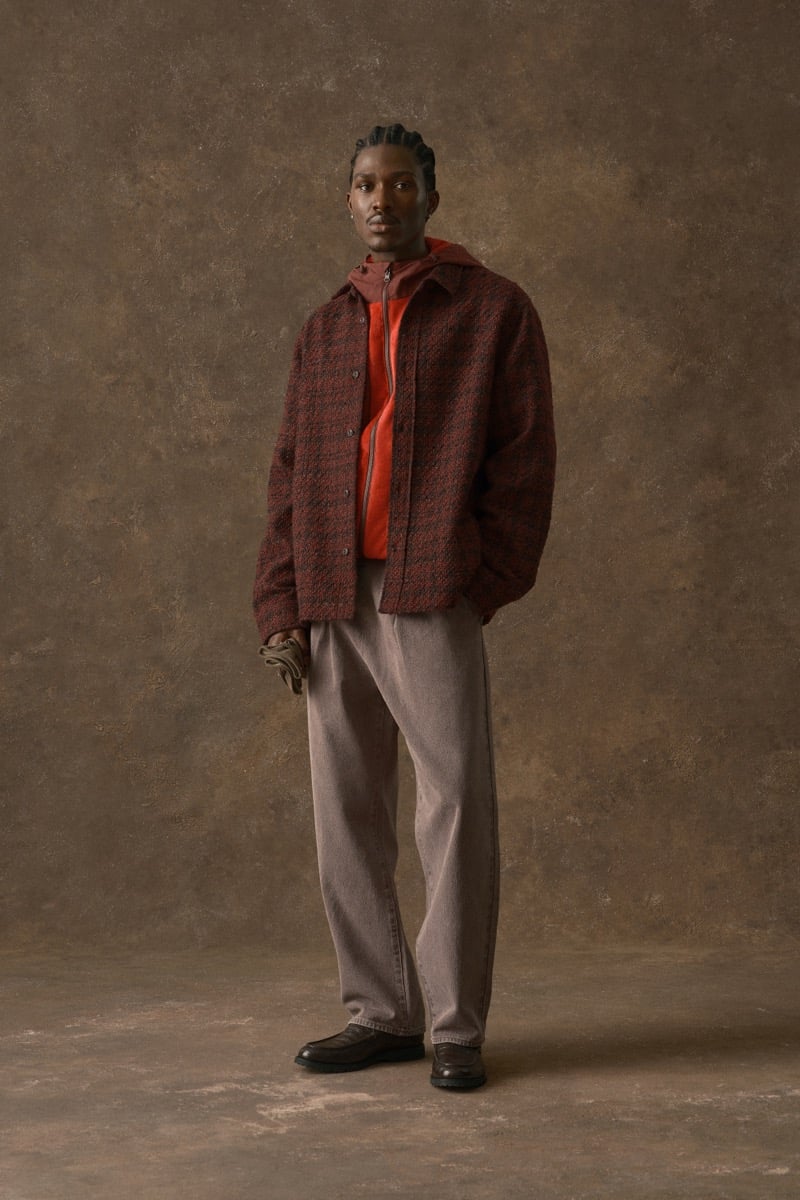 Man in a maroon plaid jacket over an orange hoodie and tan trousers, for Kith Fall 2026