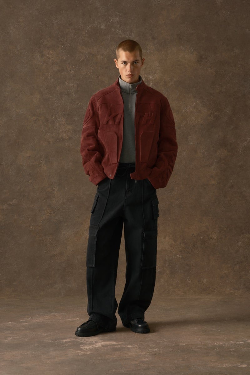 Man in a burgundy suede jacket embossed with the Kith logo, wearing black cargo trousers, for Kith Fall 2026
