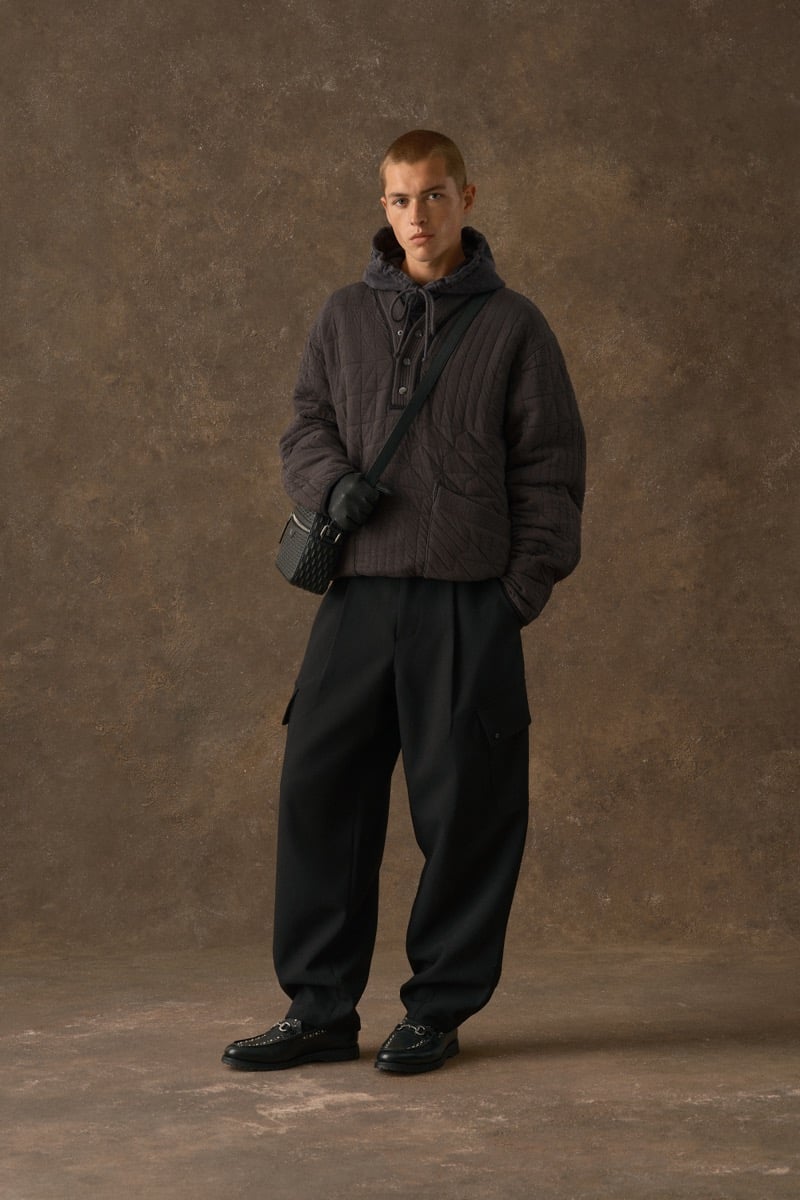 Man in a dark quilted pullover with a hood, wearing black cargo trousers, for Kith Fall 2026