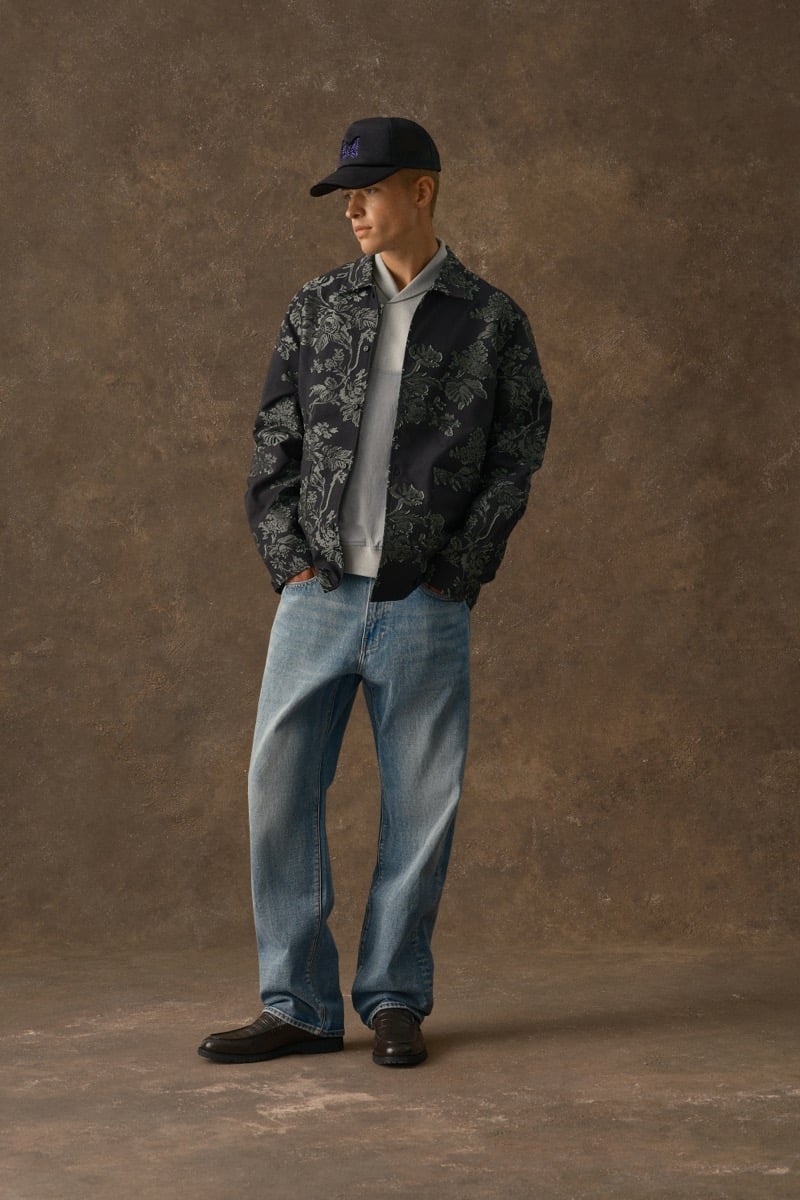 Man in a dark floral jacquard jacket, wearing a cap and light-wash jeans, for Kith Fall 2026