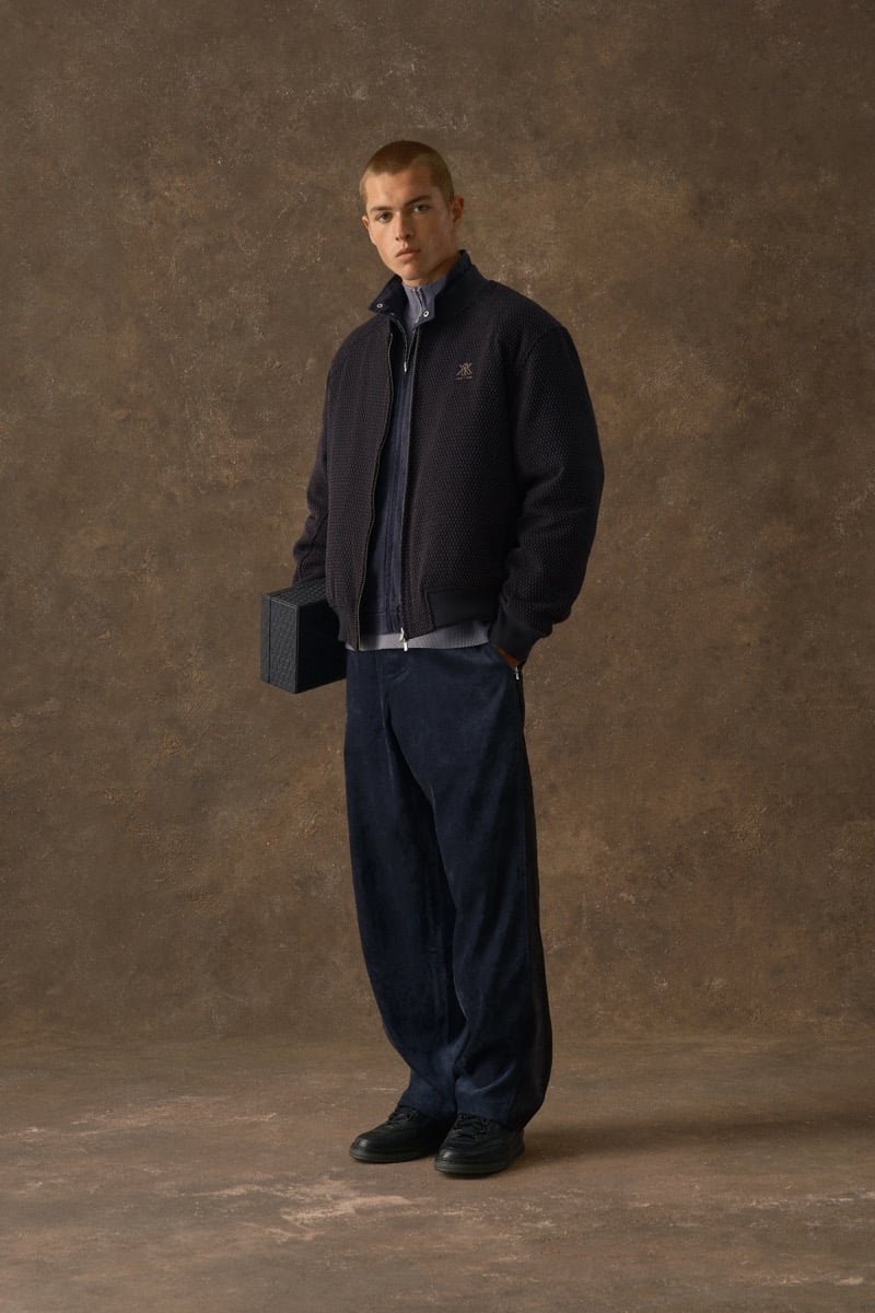 Man in a navy textured bomber jacket with an embroidered crest, wearing corduroy trousers, for Kith Fall 2026