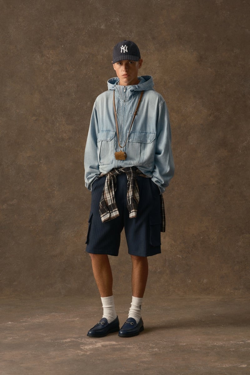 Man in a light blue denim hooded jacket with a wooden pendant necklace, a plaid shirt tied at the waist, for Kith Fall 2026