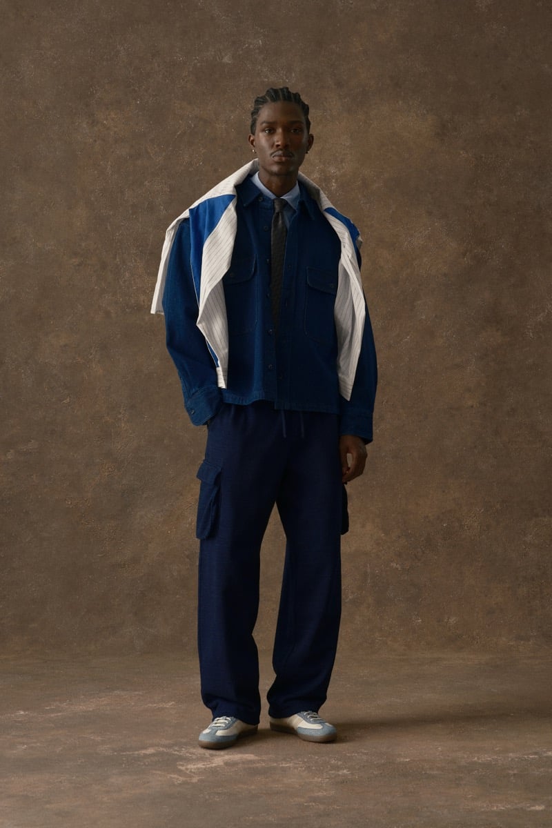 Man in a blue denim shirt-jacket with a pinstripe shirt draped over the shoulders and a tie, for Kith Fall 2026