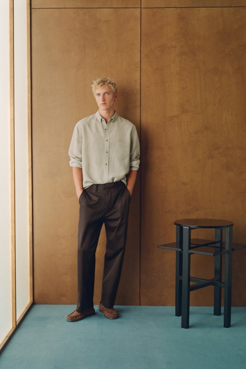 Pierrick Grégoire stands facing forward in a sage shirt, dark brown trousers, and suede loafers