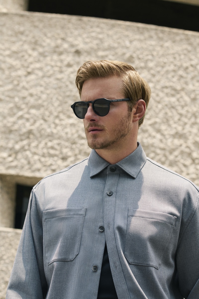 Alexander Ludwig in a gray wool shirt-jacket and round Perry Ellis sunglasses, photographed in close-up