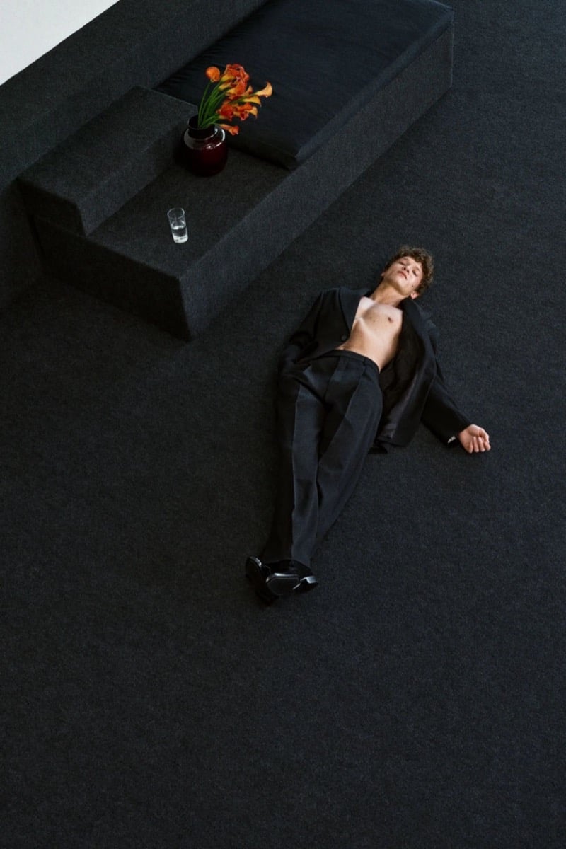 Connor lies on the floor in an open black suit jacket with no shirt underneath for Saint Laurent's fall 2026 campaign.