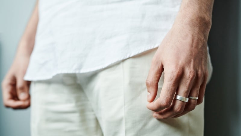 A man's hand in his pocket wearing a silver wedding band