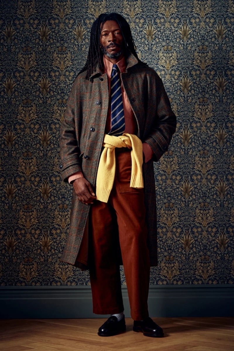 Man in a plaid wool coat with a yellow sweater tied at the waist and a striped tie, for Todd Snyder Fall 2026
