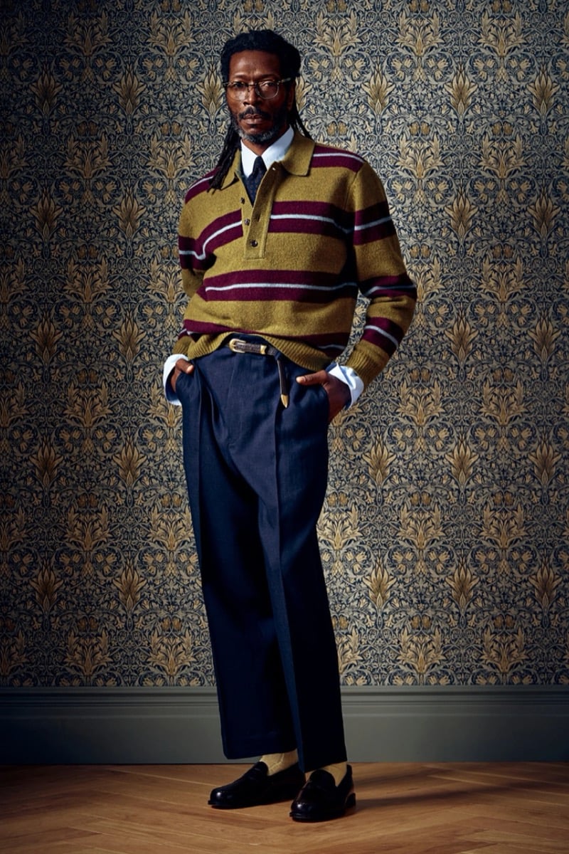 Man in a striped polo sweater, tie, and dark trousers, for Todd Snyder Fall 2026